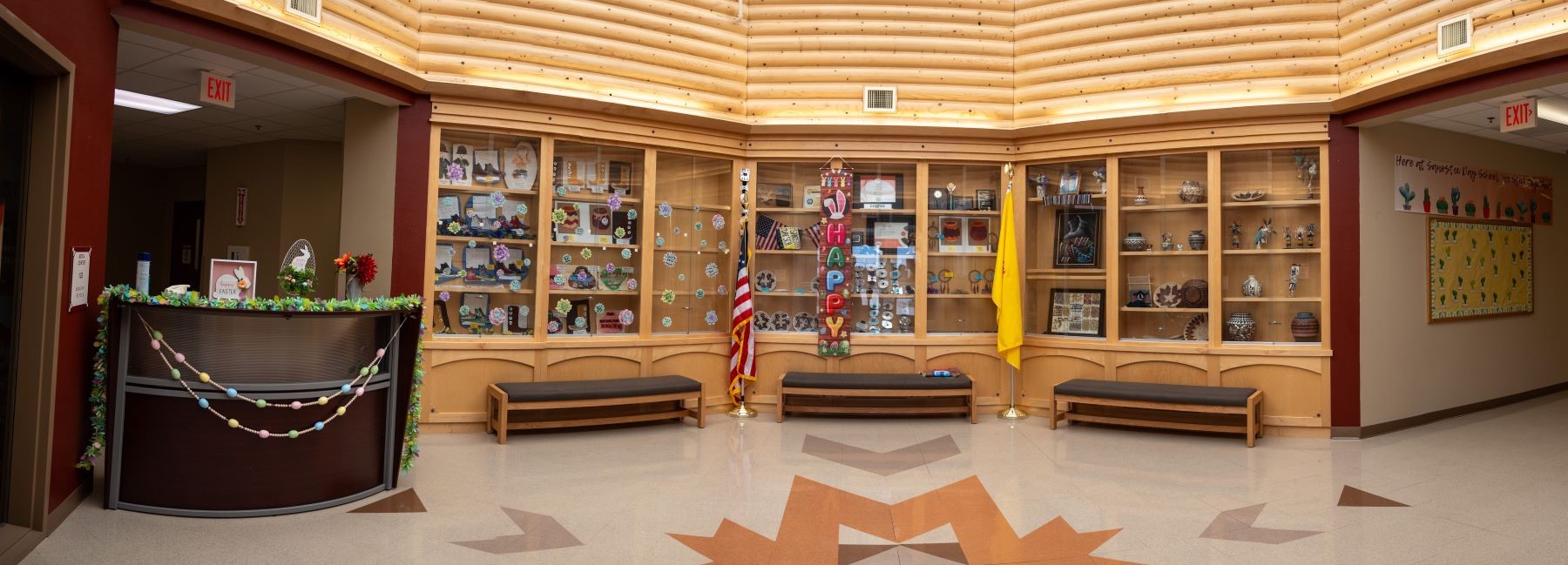 School lobby featuring a spacious area with a large wooden ceiling, creating a warm and inviting atmosphere.
