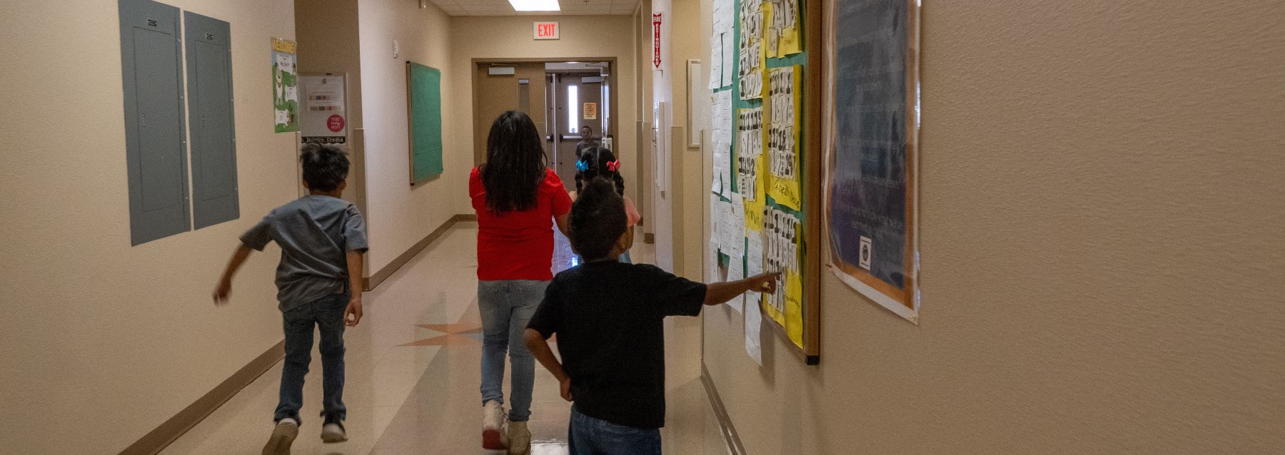 A group of children walking together down a school hallway, chatting and smiling as they head to their next class.